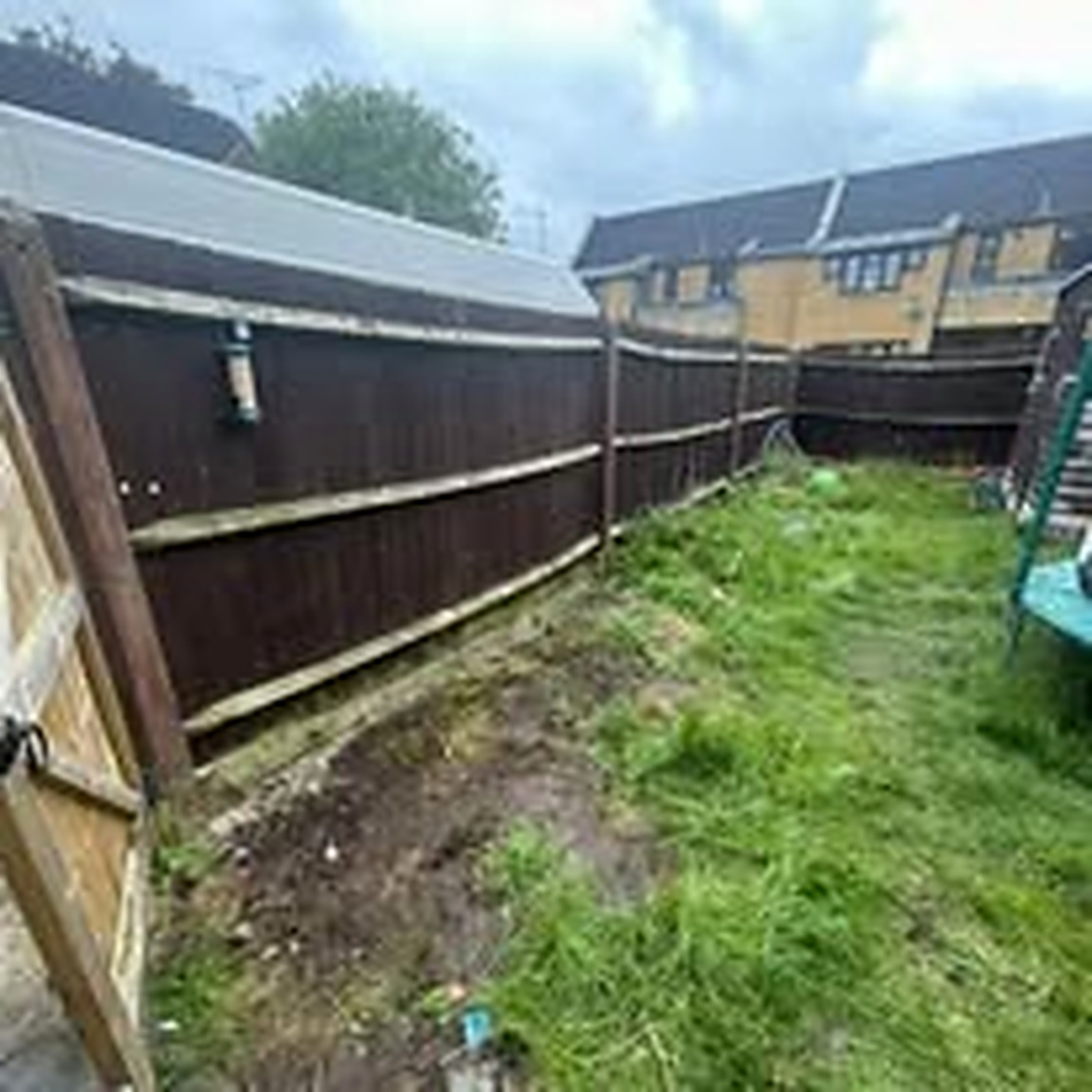 The same garden fence line completely clear and tidy after clearance
