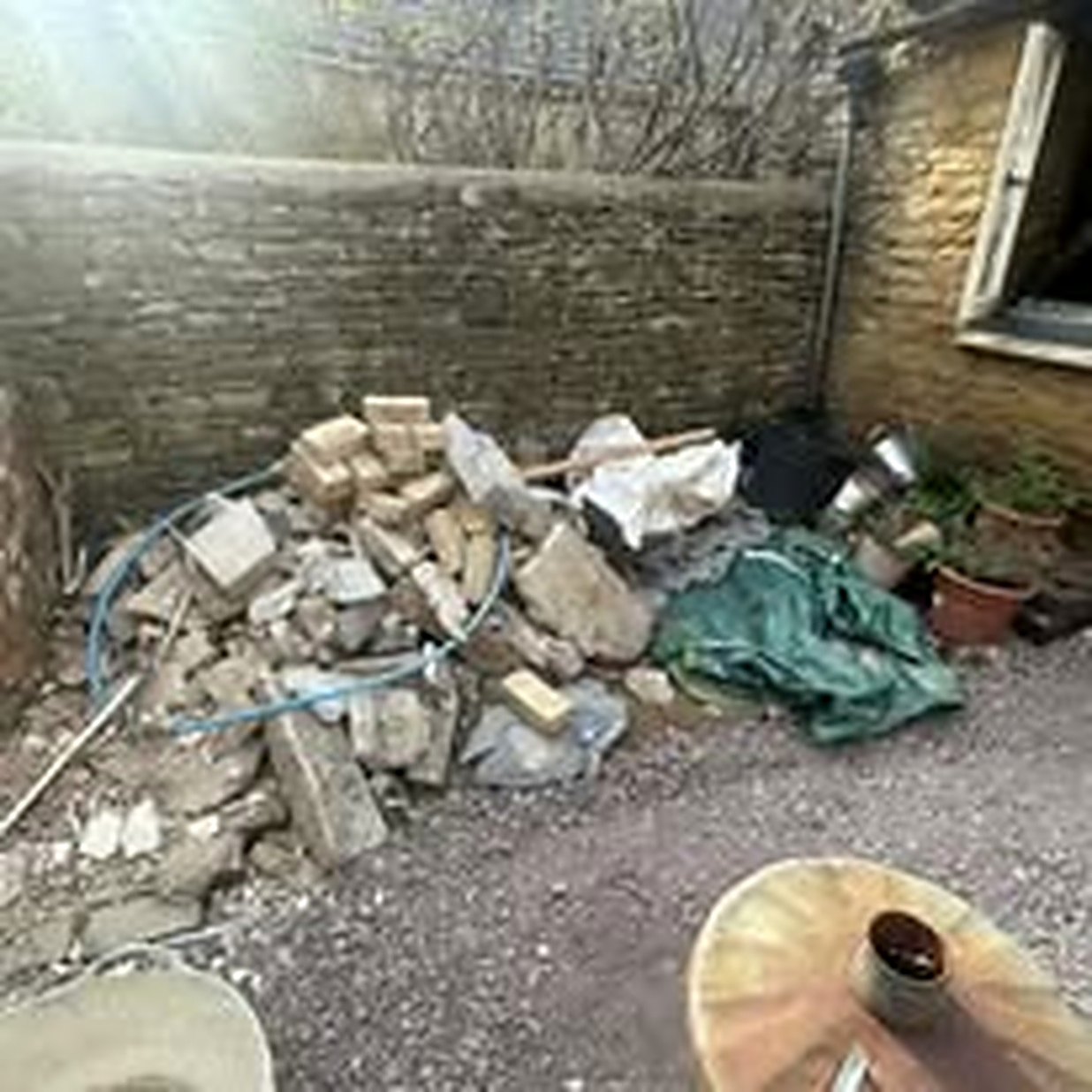 Pile of broken bricks, stone and building rubble in a courtyard before removal